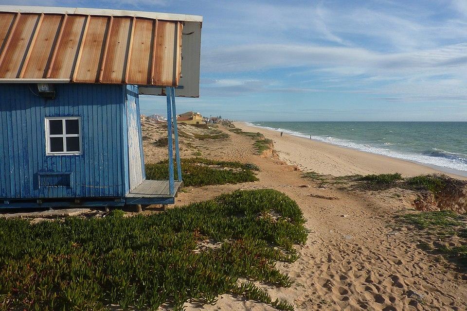 Blå strandstuga i trä och sanddyner vid Praia de Faro, Ria Formosa, Algarve, Portugal