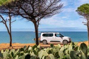Electric mini campervan by Ocean Camper parked by the beach in Portugal