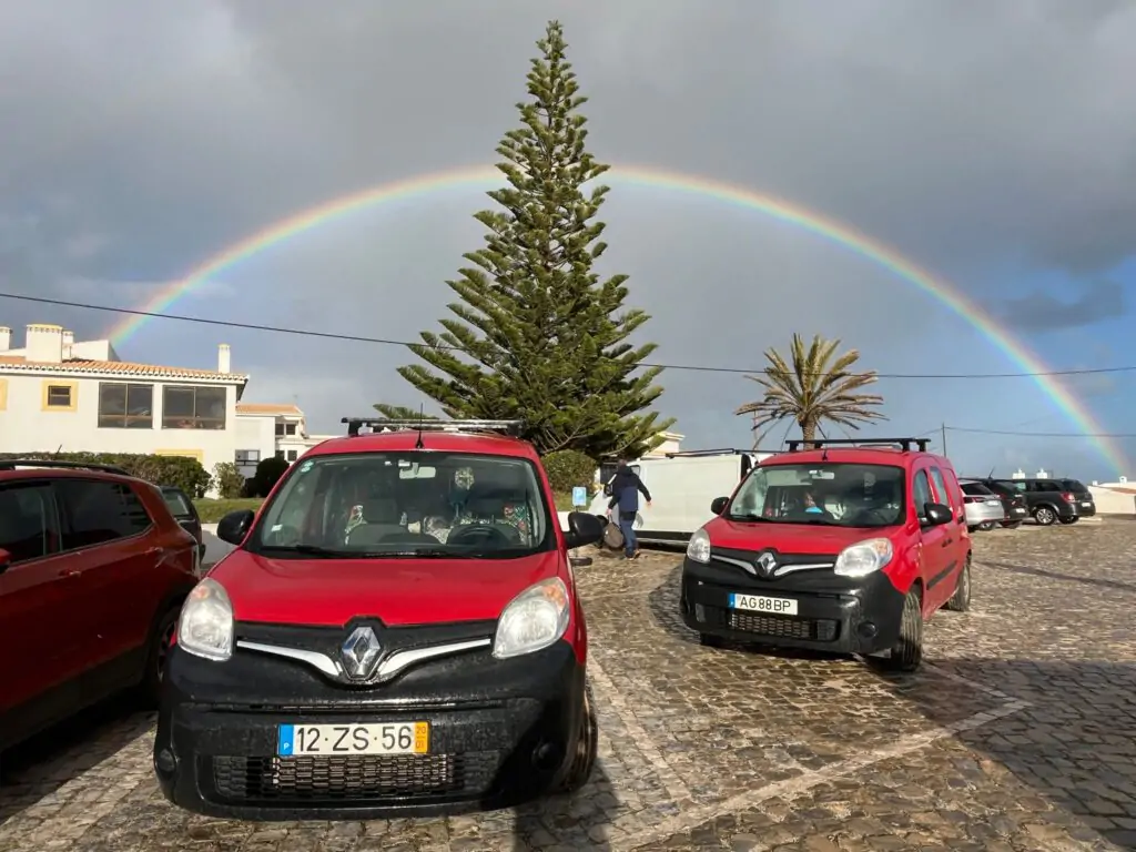 Unter einem Regenbogen in Faro, Algarve, geparkte Ocean Camper - ein Symbol für Freiheit, Natur und Abenteuer auf der Straße.