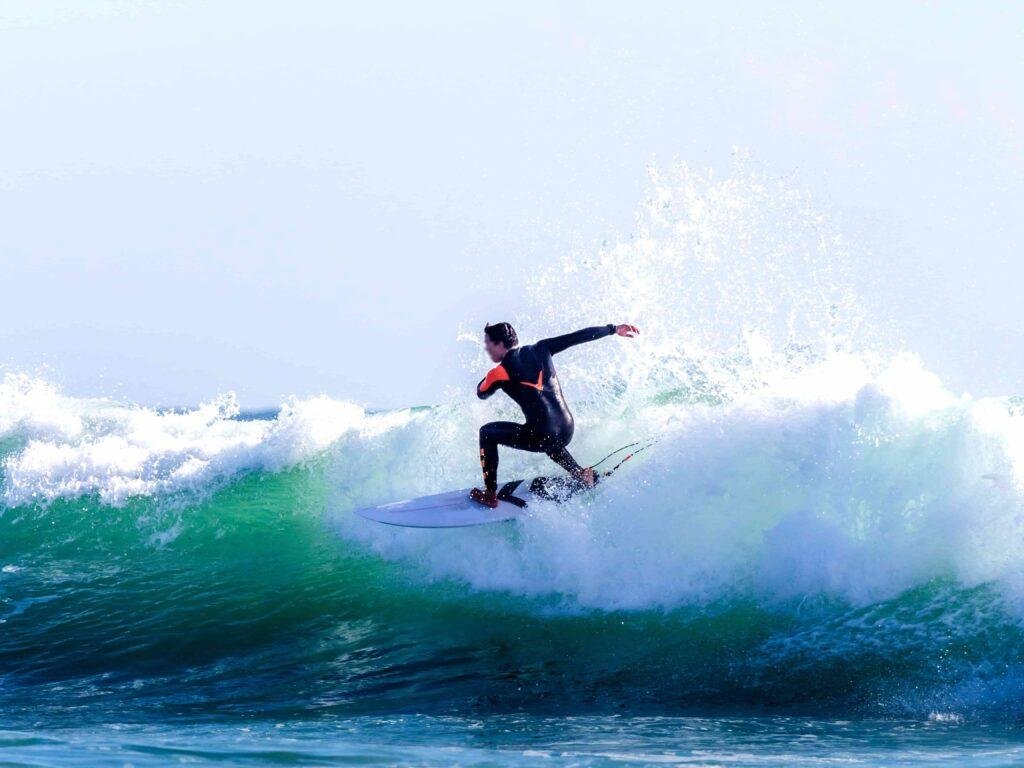 Surfer riding a wave in Algarve, Portugal, representing Ocean Camper’s surf and camp adventures.