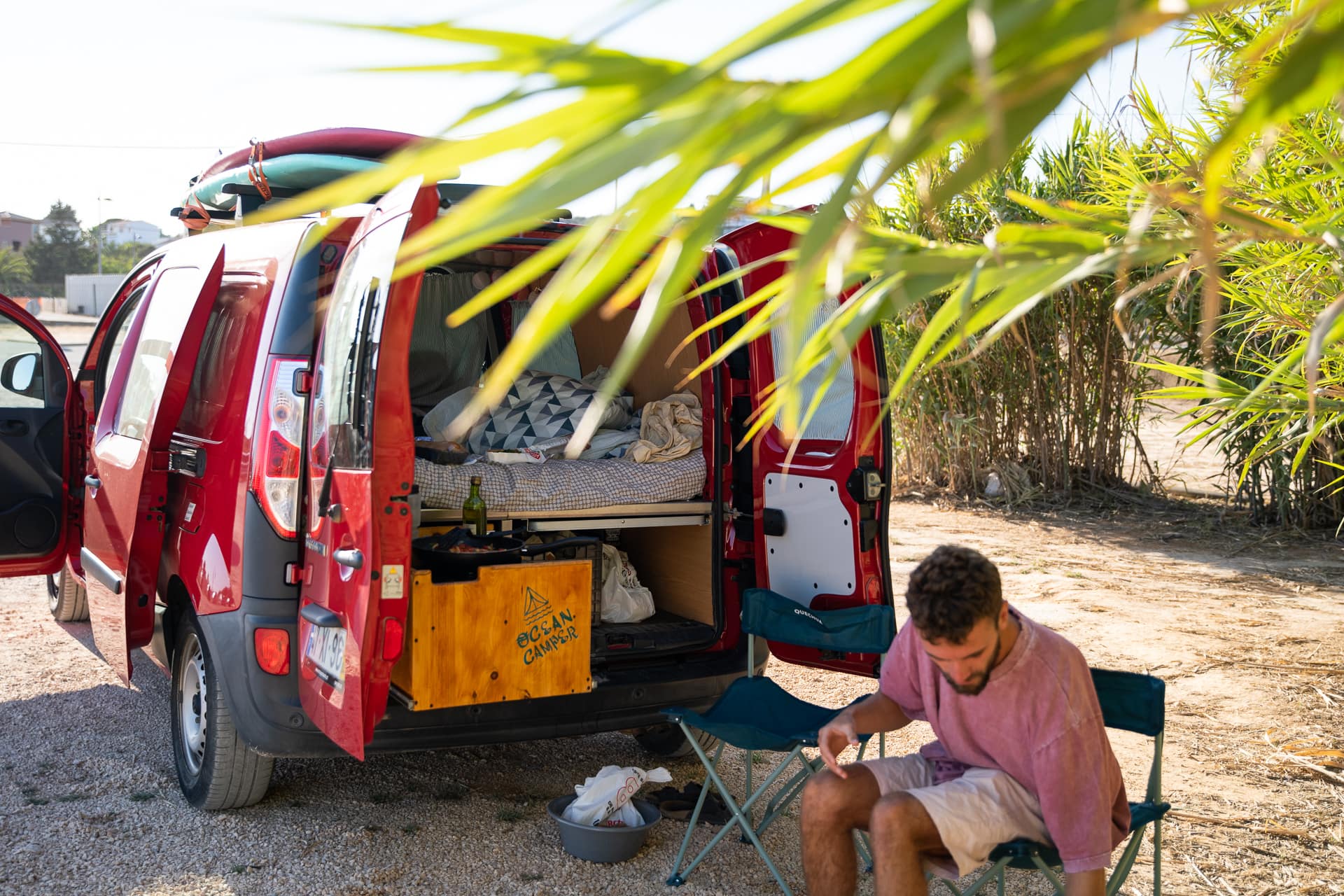 Traveler making coffee with a sea view from a campervan