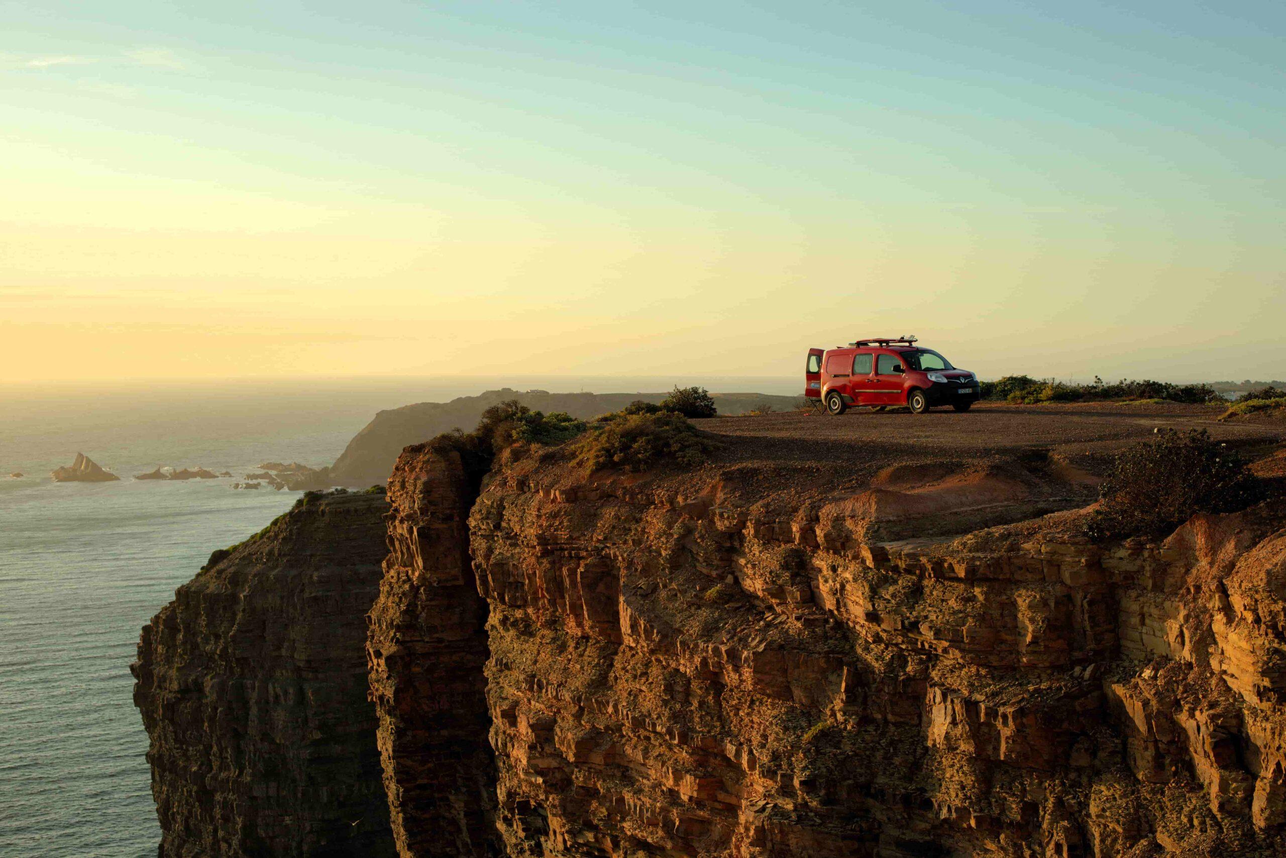 Ocean Camper van parked on Algarve cliffs at sunset — scenic view for camping and road trips in Portugal.
