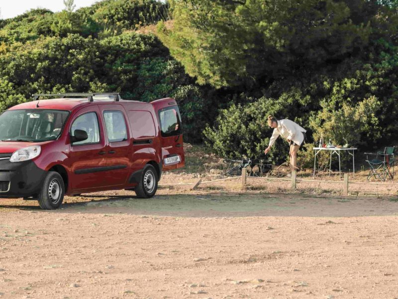 minimalist travel Portugal: Mini Campvervan parked in nature with outdoor camping setup