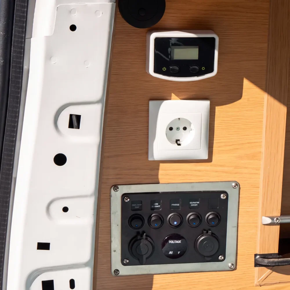 Zásuvka 230V a ovládací panel 12V namontovaný uvnitř campervanu