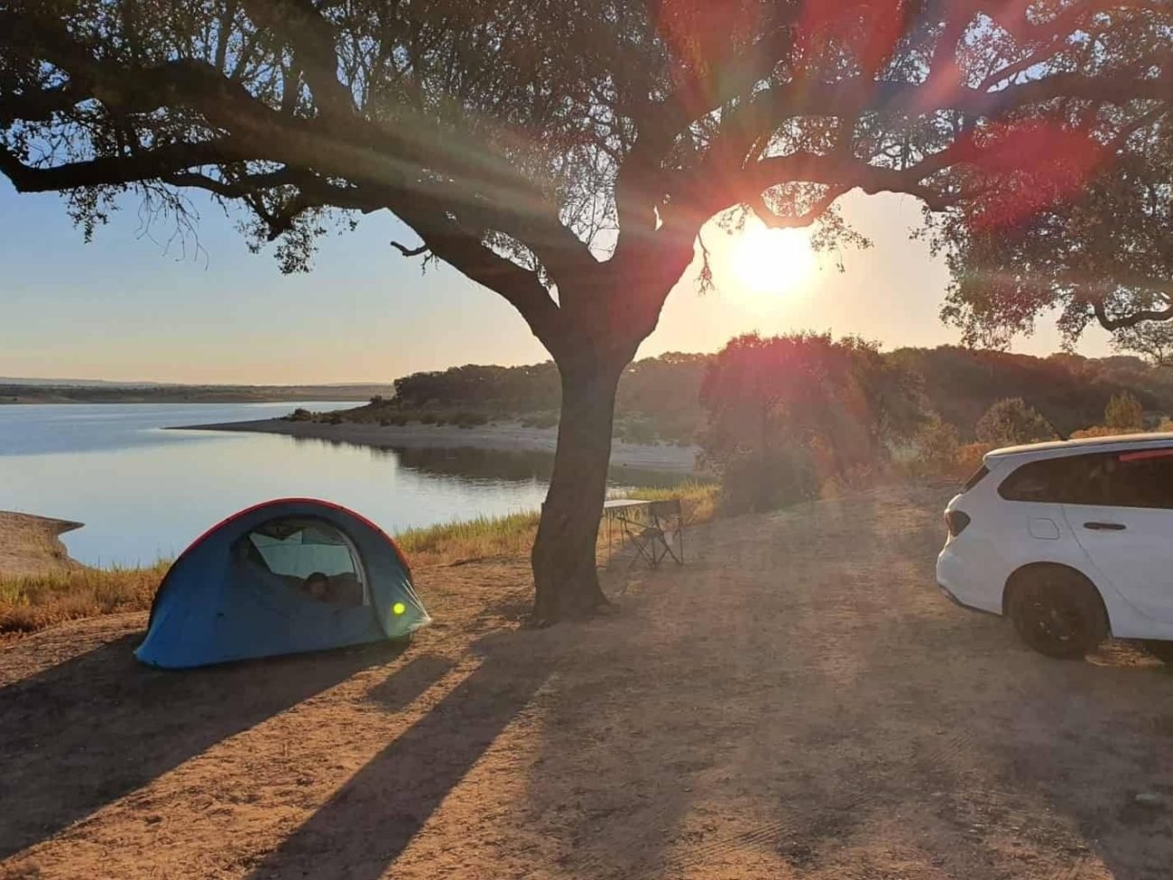 Blue camping tent by a lake at sunset in the Algarve, tent rental in Faro