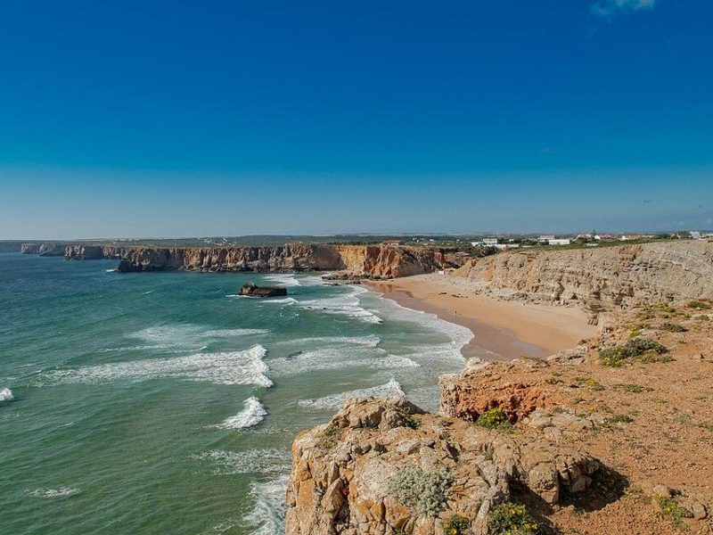Tonel Beach Sagres con onde potenti, scogliere e surfisti - spot esposto sulla costa occidentale dell'Algarve.